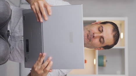 Vertical-video-of-Man-joyfully-embracing-laptop.